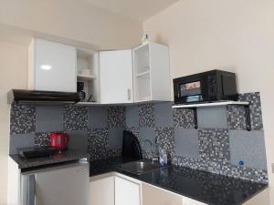a kitchen with a sink and a microwave at Home in the Heart of Cagayan De Oro City in Cagayan de Oro