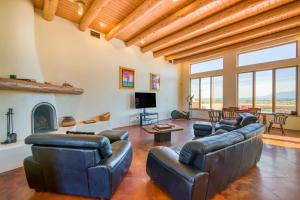 ein Wohnzimmer mit Ledermöbeln und einem Kamin in der Unterkunft Southwest Stunner in Ranchos de Taos