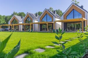 dom z zielonym trawnikiem przed nim w obiekcie Mare Boutique Houses w mieście Niechorze