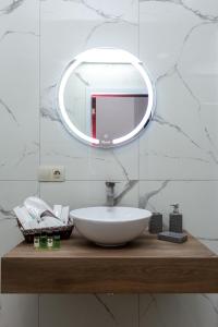 uma casa de banho com um lavatório branco e um espelho. em Saburtalo Apartment em Tbilisi