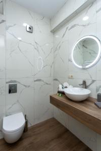 a white bathroom with a sink and a mirror at Saburtalo Apartment in Tbilisi City