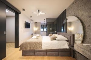 sypialnia z dużym łóżkiem z dużym lustrem w obiekcie LL luxury penthouse on sea w Bibinje