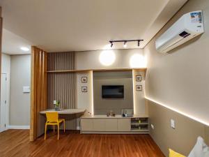 a small living room with a table and a tv at Apartamentos Studio no centro de Foz do Iguaçu in Foz do Iguaçu