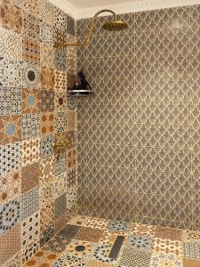 bagno con doccia e piastrelle sul muro di Riad Dar Yassine a Marrakech