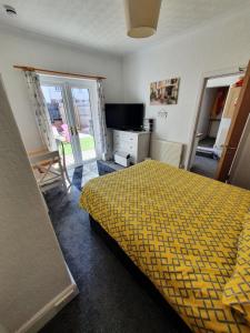 TV a/nebo společenská místnost v ubytování PINK HOUSE ,Opposite Beach ,SLEEPS 6 , 2 BEDROOM GROUND FLOOR SELF CONTAINED GARDEN FLAT , PRIVATE ENTRANCE , KITCHEN , Guaranteed Parking ,Wifi , Movies ,Bathroom ,fridge , microwave ,BEDROOM 1, DOUBLE BED & 2 SINGLE BEDS ,BEDROOM 2 , DOUBLE BED