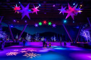 a group of people on an ice rink with christmas lights at Ski In Ski Out 3BR Townhome in Creekside by Harmony Whistler in Whistler