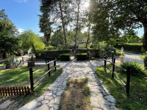 a stone path in a park with a fence at Antiche Dimore Vescovado in Murlo