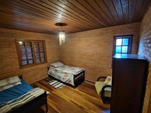 a small room with two beds and a window at toda paz do universo in Nova Friburgo