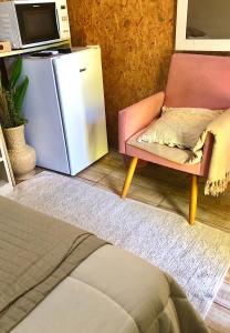um frigorífico e uma cadeira num quarto em Mandala Camping Pousada em Florianópolis
