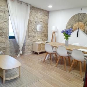 a dining room with a wooden table and chairs at Casa Elvira, terraza con fabulosas vistas in Pontevedra