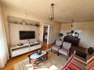 ein Wohnzimmer mit Sofa und Fernseher in der Unterkunft Casa da Linda in Bento Gonçalves