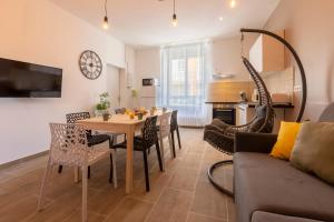 ein Wohnzimmer mit Tisch und Stühlen und einer Couch in der Unterkunft LOC TROTTEUR LE CACAO - Balnéo, Gare Lourdes in Lourdes