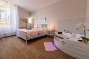 1 Schlafzimmer mit einem Bett und einer Badewanne neben einer Badewanne in der Unterkunft LOC TROTTEUR LE CACAO - Balnéo, Gare Lourdes in Lourdes