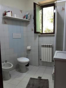 Baño blanco con aseo y lavamanos en Casa Ta-Pù a Passolanciano, en Pretoro