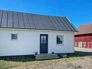 una casa blanca con una puerta negra y un granero rojo en 4 person holiday home in FALK PING en Falköping