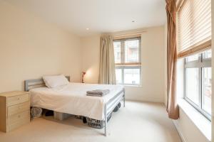 a bedroom with a bed and a window at 2 BR flat next to Train Station & Gated Parking in Cambridge