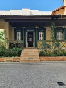 een huis met een groene deur en een trap die naar het huis leidt bij Casa Villa Constanza in Itaipava