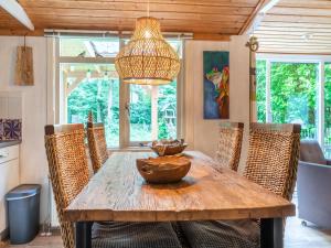 ein Esszimmer mit einem Holztisch und Stühlen in der Unterkunft Picturesque cottage on Park Hunzebergen in Exloo