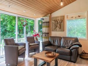 ein Wohnzimmer mit einem Sofa und 2 Stühlen in der Unterkunft Picturesque cottage on Park Hunzebergen in Exloo