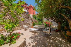 a patio with benches and flowers in front of a building at Dbhousetaormina in Taormina