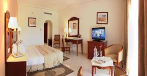 a hotel room with a bed and a television at Grand Mogador Agdal in Marrakesh