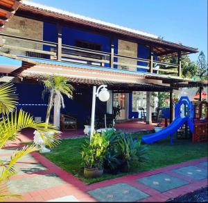 a blue house with a playground and a slide at Pousada Belmare Eireli in Rio das Ostras