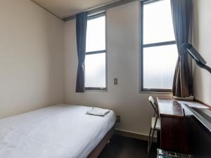 מיטה או מיטות בחדר ב-Tabist Business Hotel Suehiro Matsuyama