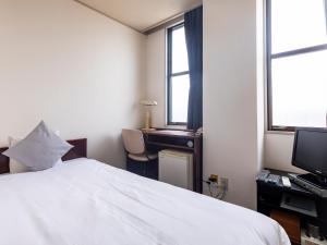 Postel nebo postele na pokoji v ubytování Tabist Business Hotel Suehiro Matsuyama