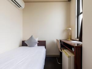 Postel nebo postele na pokoji v ubytování Tabist Business Hotel Suehiro Matsuyama