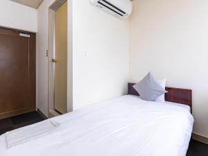 Postel nebo postele na pokoji v ubytování Tabist Business Hotel Suehiro Matsuyama