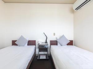Postel nebo postele na pokoji v ubytování Tabist Business Hotel Suehiro Matsuyama