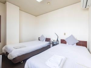 Postel nebo postele na pokoji v ubytování Tabist Business Hotel Suehiro Matsuyama