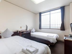 Postel nebo postele na pokoji v ubytování Tabist Business Hotel Suehiro Matsuyama