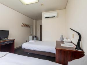 Postel nebo postele na pokoji v ubytování Tabist Business Hotel Suehiro Matsuyama