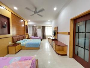 a hotel room with two beds and a television at Jiaxin Homestay - Desa Terbau 家馨民宿 in Johor Bahru