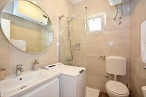 a bathroom with a toilet and a sink and a mirror at Apartment 'MIMO' in Milna - Hvar in Milna