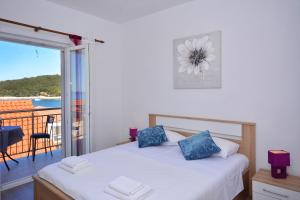 a bedroom with a bed and a balcony at Apartment 'MIMO' in Milna - Hvar in Milna