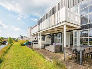 een huis met een patio met een tafel en stoelen bij 7 person holiday home on a holiday park in Ebeltoft in Ebeltoft