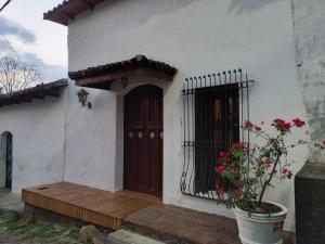 ein weißes Haus mit einer Tür und einer Veranda in der Unterkunft Casa Flor de Pajaro, vistas panorámicas increíbles al lago in Suchitoto
