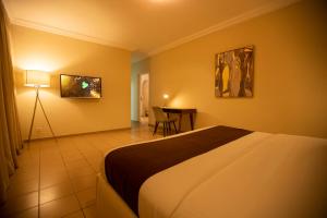 Habitación de hotel con cama y mesa en La baie des orchidées, en Abiyán