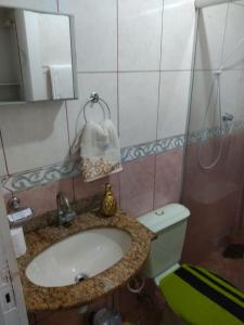 y baño con lavabo, aseo y espejo. en STUDIO Centro Lacerda, en Campos dos Goytacazes