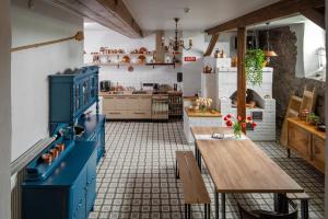 uma cozinha com armários azuis e uma mesa de madeira em Viesu nams Donas em Blome