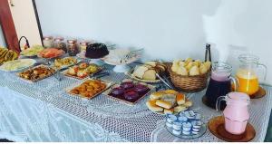 a table topped with different types of food and drinks at Pousada da Jaqueira - EPP in Rio das Ostras