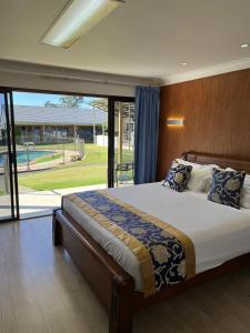 a bedroom with a large bed and a large window at Oxley Motor Inn in Brisbane