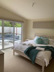 a bedroom with a large bed and a large window at Contemporary On Cuttriss Inlet Side in Inverloch