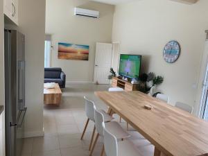 Una sala de estar con una mesa y sillas de madera. en Contemporary On Cuttriss - Inlet Side, en Inverloch 4 fotos más
