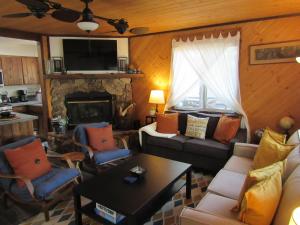 een woonkamer met een bank en een open haard bij Lazy Pines in Sugarloaf