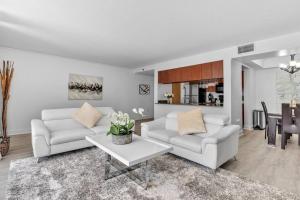 una sala de estar con 2 sofás blancos y una mesa. en Modern 2/2 with Beautiful Ocean and Brickell Views, en Miami