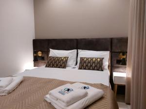 Un dormitorio con una cama grande con toallas. en Liris Holiday Apartments, en Nazaré
