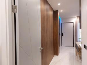 a hallway with a wooden door and a white wall at Liris Holiday Apartments in Nazaré